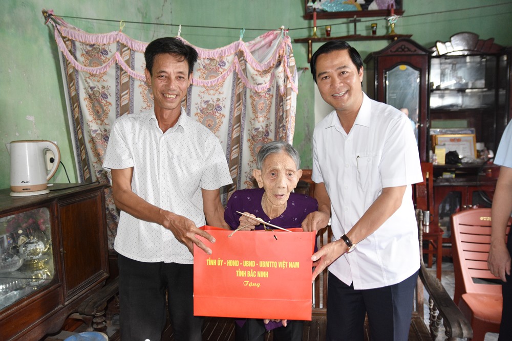 Đồng chí Lê Xuân Lợi tặng quà cụ Chu Thị Thưởng ở xã Trung Chính.