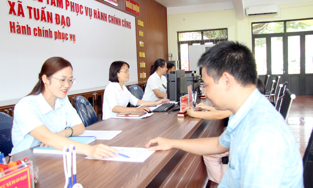 Cán bộ Trung tâm phục vụ hành chính công xã Tuấn Đạo hướng dẫn người dân nộp hồ sơ thủ tục hành chính.