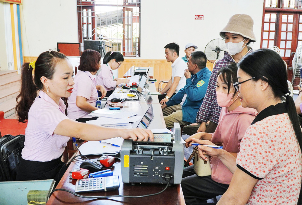 Cán bộ Phòng giao dịch Ngân hàng chính sách xã hội Việt Yên giải ngân vốn vay tại Điểm giao dịch phường Tự Lạn.