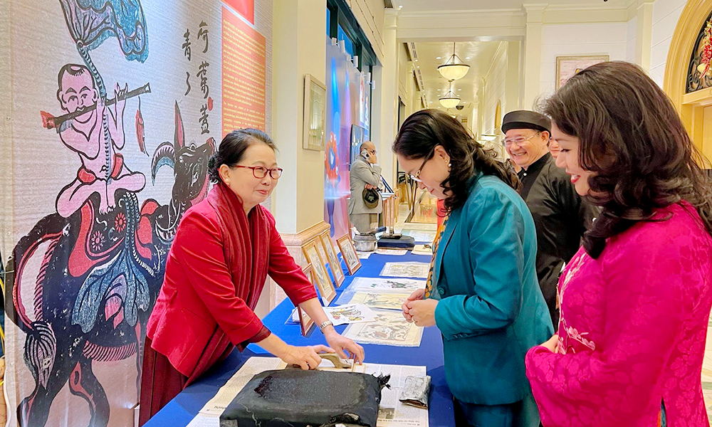 Nghệ nhân ưu tú Nguyễn Thị Oanh giới thiệu công đoạn làm tranh Đông Hồ với du khách.
