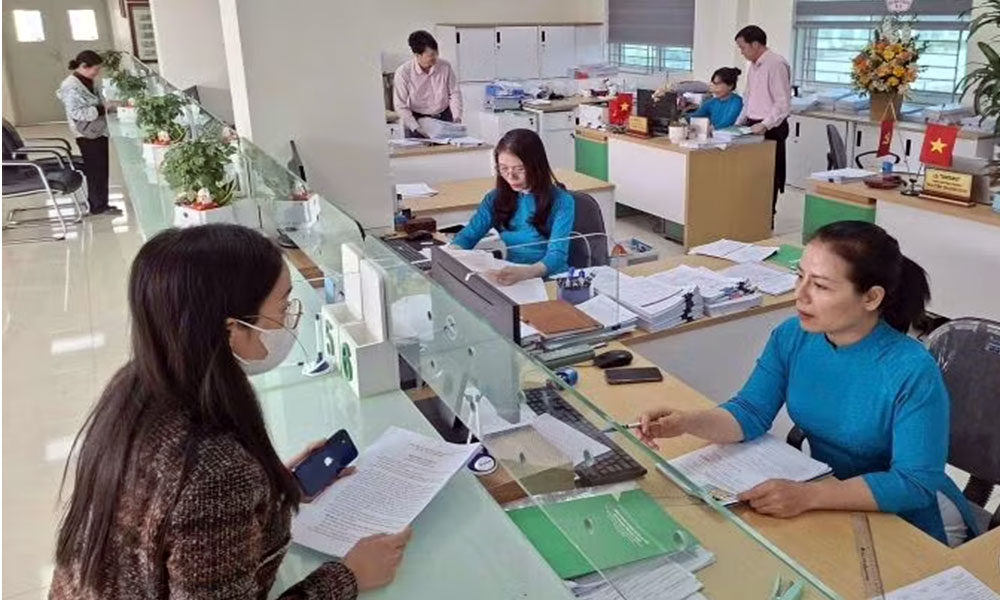 Cán bộ ngân hàng Chính sách xã hội tỉnh Bắc Ninh tư vấn khách hàng đến vay tiền mua nhà ở xã hội.