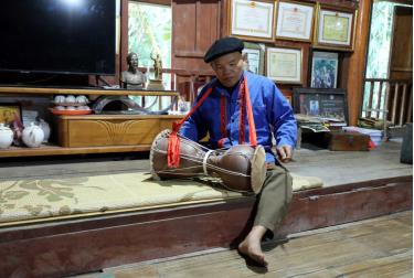 Nghệ nhân Nhân dân Sầm Văn Dừn biểu diễn trống sành nhạc cụ truyền thống của đồng bào dân tộc Cao Lan. (Ảnh: Quang Cường/TTXVN)