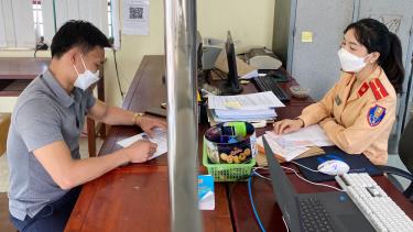 Trung úy Mễ Thị An (Công an huyện Sơn Động) hướng dẫn người dân làm thủ tục hành chính. Ảnh: CTV