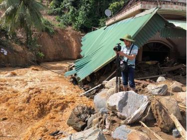 Phóng viên Cơ quan thường trú TTXVN tại Nghệ An Nguyễn Văn Tý ghi hình lũ quét tại huyện Kỳ Sơn (Nghệ An), tháng 10/2022. Ảnh: TTXVN
